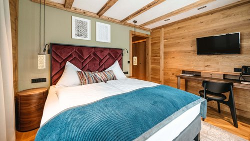 Ihr Hotel in St. Christoph am Arlberg Modernes Schlafzimmer mit Holzdecke, Doppelbett und Fernseher an der Wand