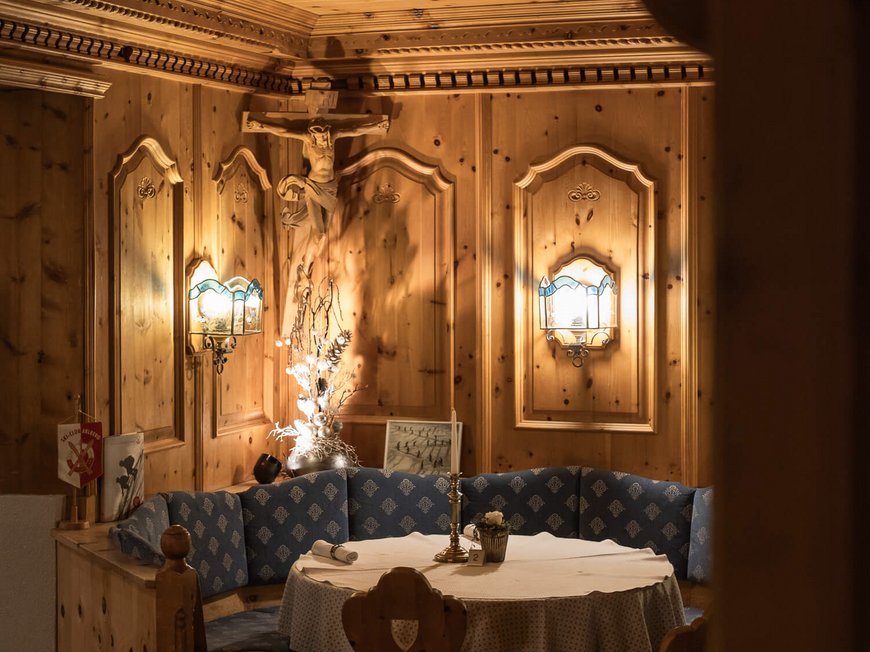 Maiensee, Ihr Hotel in Sankt Christoph: Kulinarik Gemütliche Holzecke mit rundem Tisch und blauem Polstersofa in traditionellem Stil