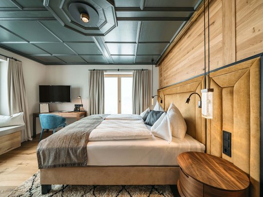 Ihr Hotel in St. Christoph am Arlberg Modern eingerichtetes Hotelzimmer mit großem Bett, Holzdetails und TV
