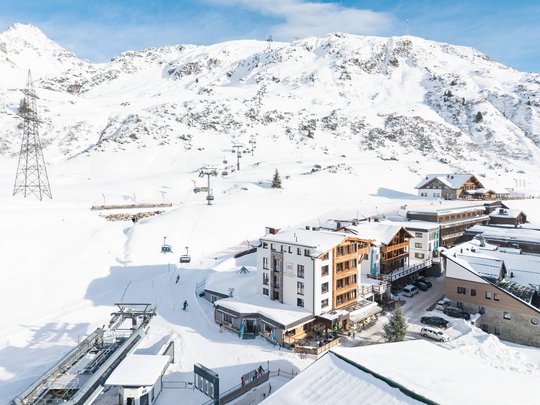 Ihr Hotel in St. Christoph am Arlberg Schneebedecktes Bergdorf mit Skilift und Berg im Hintergrund