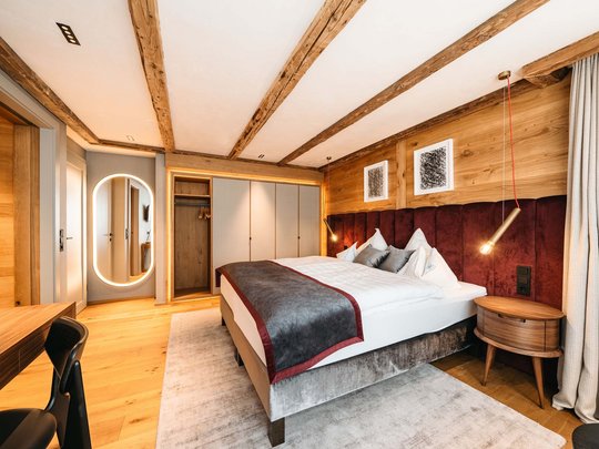 Ihr Hotel in St. Christoph am Arlberg Gemütliches modernes Schlafzimmer mit Holzelementen und weichem Teppich