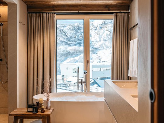 Das Maiensee: Ihr Hotel in St. Christoph Modernes Badezimmer mit freistehender Badewanne und Bergblick