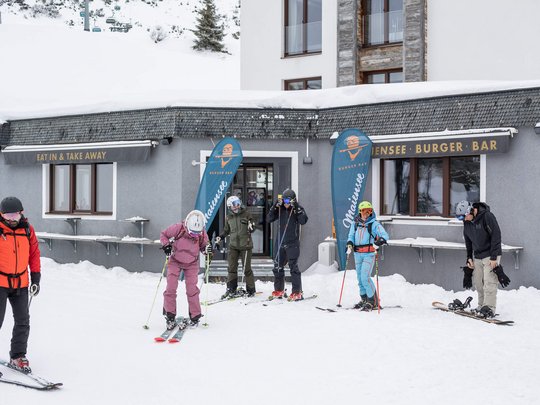 Das Maiensee: Ihr Hotel in St. Christoph Skifahrer vor einem Burger-Bar-Gebäude im Schnee
