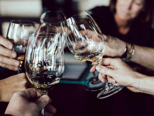 Die Lounge-Bar in Ihrem Skihotel am Arlberg Menschen stoßen mit Weingläsern bei einem Treffen an