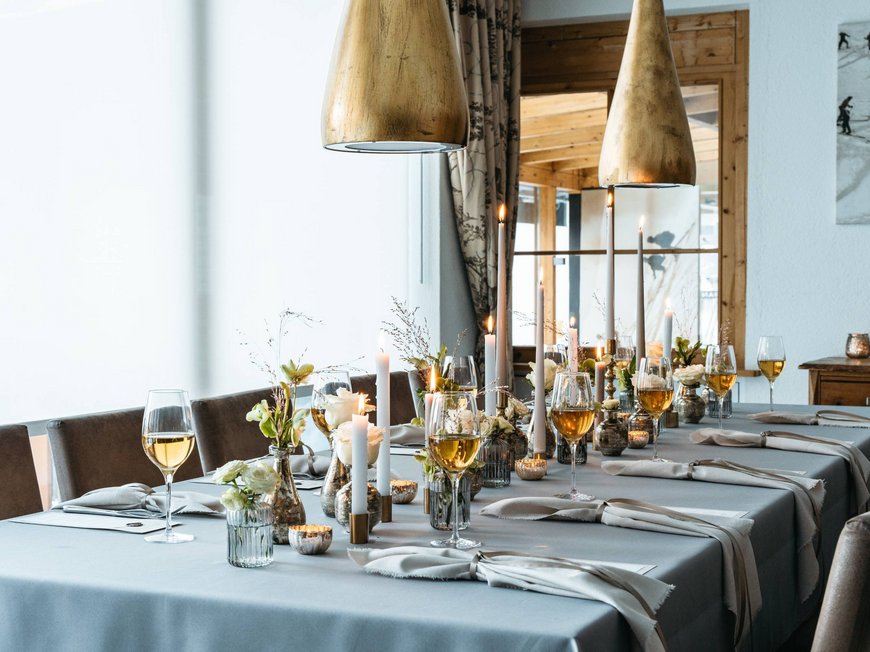 Ihr Hotel in St. Christoph am Arlberg Eleganter gedeckter Esstisch mit Kerzen, Blumen und Weingläsern in einem Restaurant