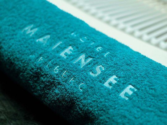 Hotel Maiensee: Wellness nahe St. Anton am Arlberg Blaues Badetuch mit Aufschrift am Rand eines Pools
