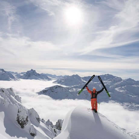 Ihre Unterkunft in St. Christoph am Arlberg: Bilder Skifahrer steht mit erhobenen Skiern auf schneebedecktem Berggipfel