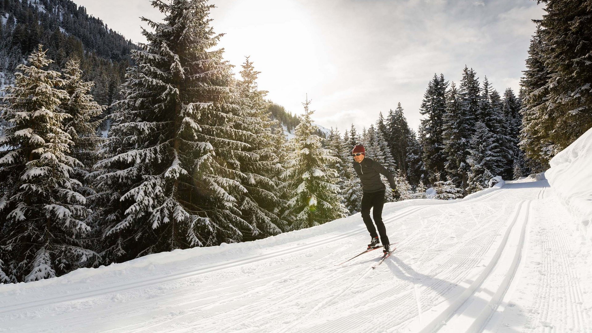 Hotel Maiensee: Wintersport am Arlberg Skifahrer auf verschneiter Loipe im sonnigen Winterwald