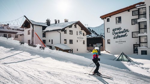 Ihr Hotel in St. Christoph am Arlberg Skifahrer vor schneebedeckten Hotels in einer sonnigen Berglandschaft