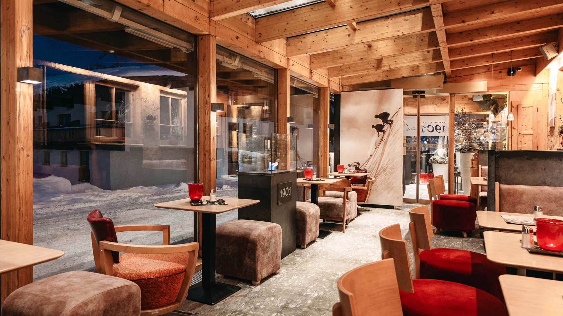 Ihre Veranstaltung in unserem Hotel nahe St. Anton Gemütliches Café mit Holzdecke und großen Fenstern mit Blick auf verschneite Straße