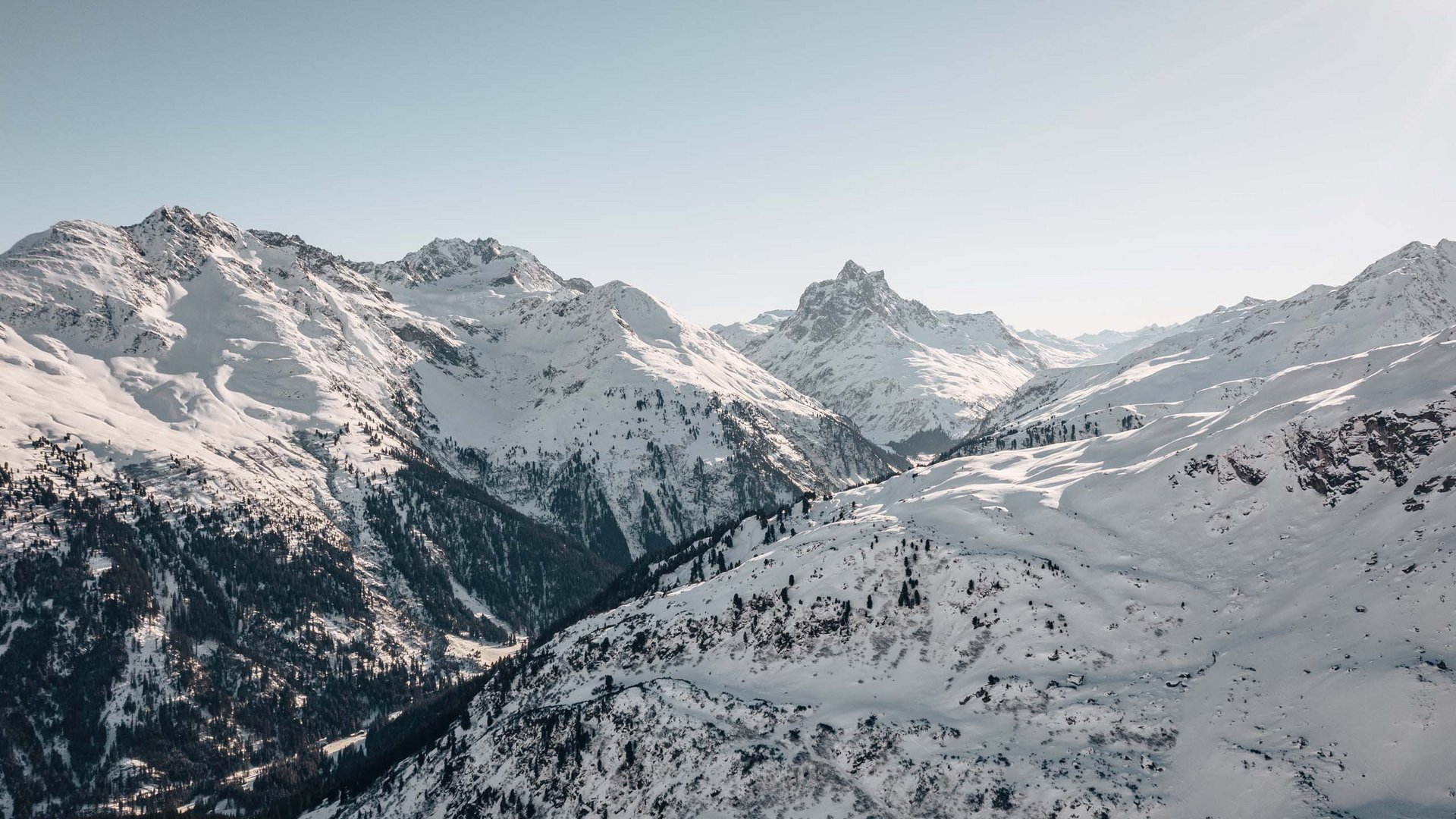 Holidays at the Arlberg: your hosts Snow-covered mountains under clear sky on a sunny winter day