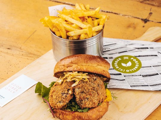 Burger im Skihotel in St. Anton am Arlberg Vegetarischer Burger mit Pommes Frites auf einem Holzbrett serviert