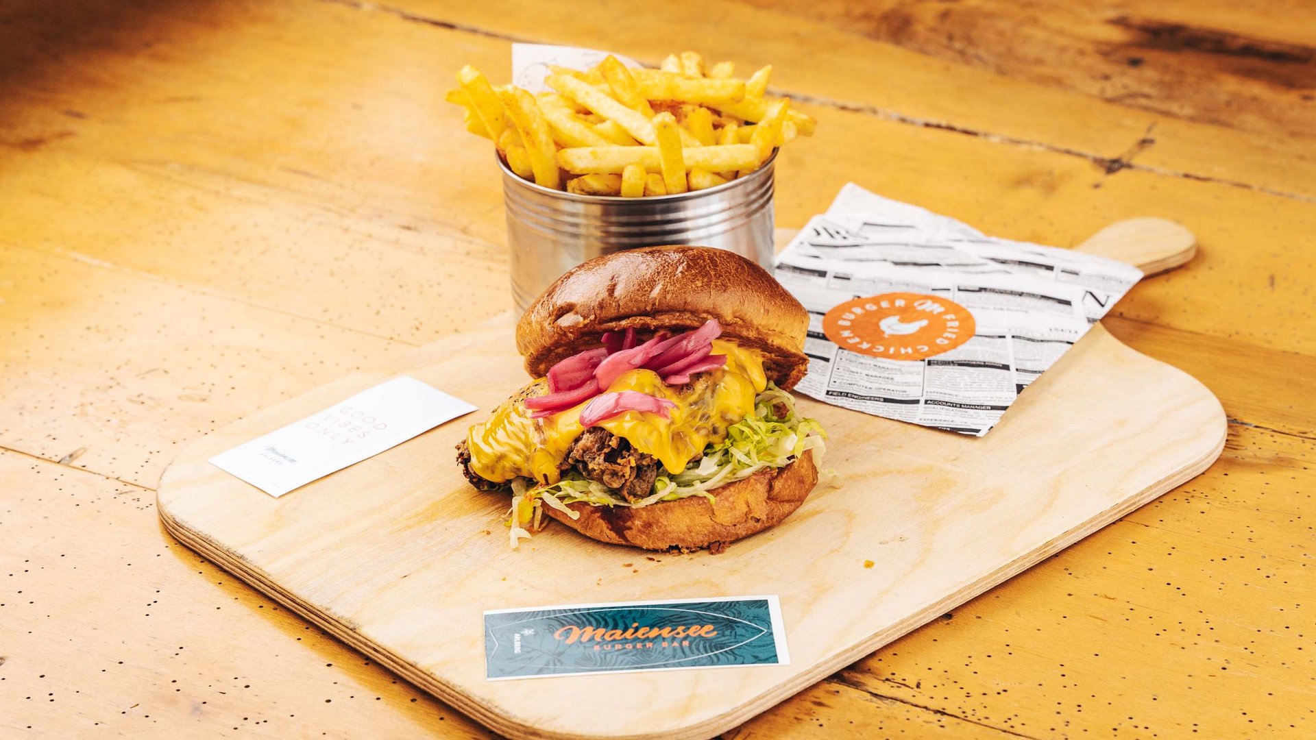 Burger im Skihotel in St. Anton am Arlberg Burger mit Käse, Salat und Pommes auf Holzbrett serviert