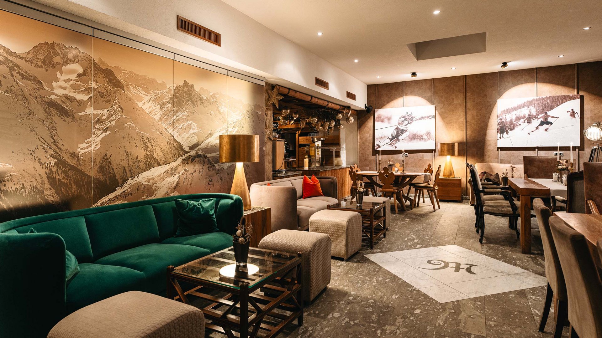 Ihre Veranstaltung in unserem Hotel nahe St. Anton Gemütlicher Gastronomiebereich mit Bergbild und Holzmöbeln