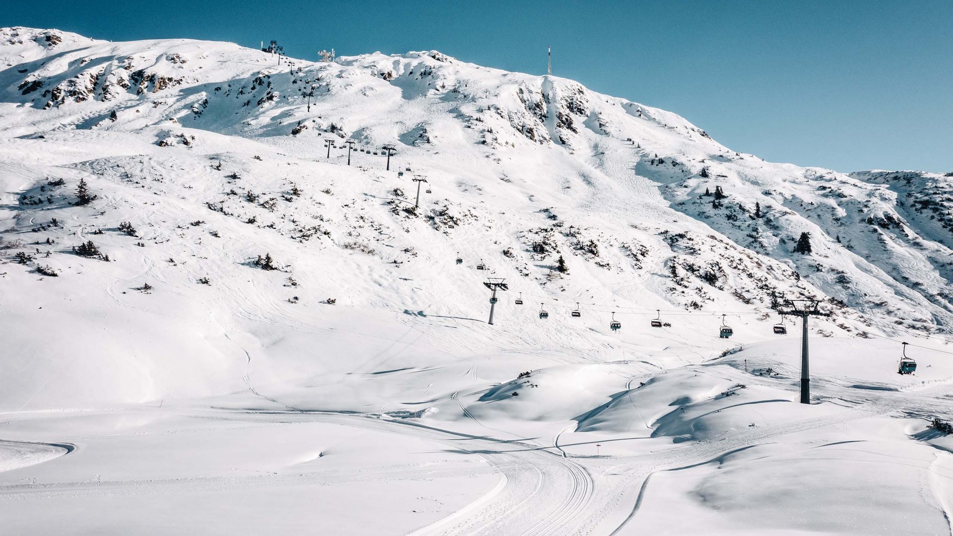 Holidays at the Arlberg: your hosts Snow-covered mountain with ski lift and clear sky