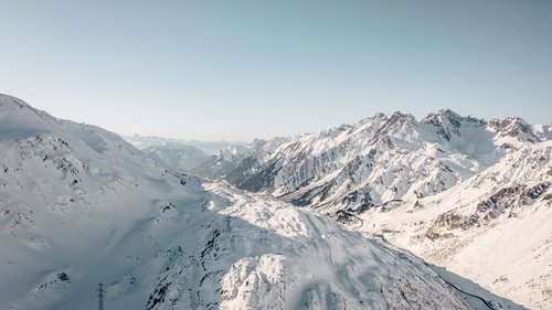 Ihr Hotel in St. Christoph am Arlberg Verschneite Alpenberge unter klarem Himmel mit Sicht auf ein Tal und Straße