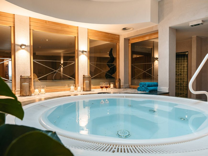 Ihr Hotel in St. Christoph am Arlberg Runder Whirlpool in einem modernen Wellnessraum mit Kerzen und Handtüchern