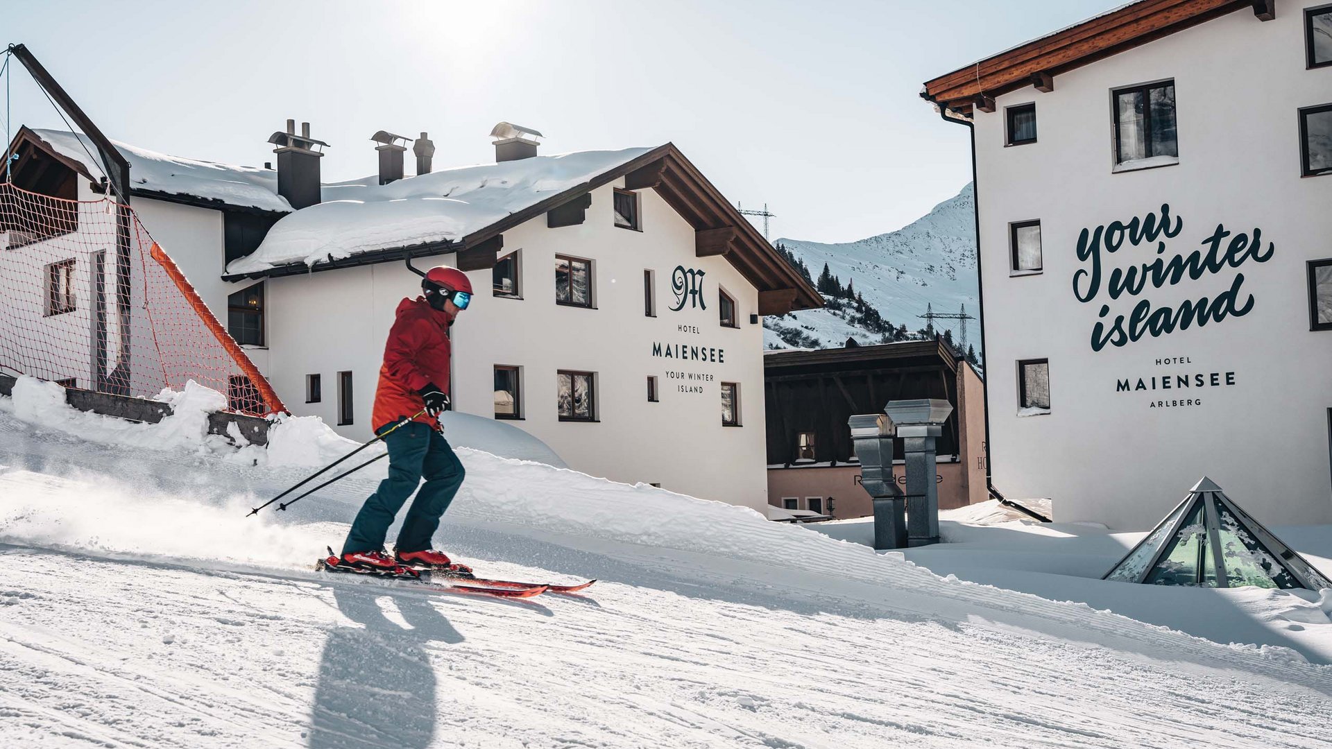 Hotel Maiensee: Wintersport am Arlberg Skifahrer vor verschneitem Hotel Maiensee in den Bergen am sonnigen Wintertag