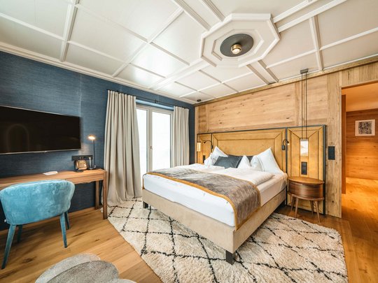 Das Maiensee: Ihr Hotel in St. Christoph Gemütliches Schlafzimmer mit Holzwänden, Doppelbett und Fernseher