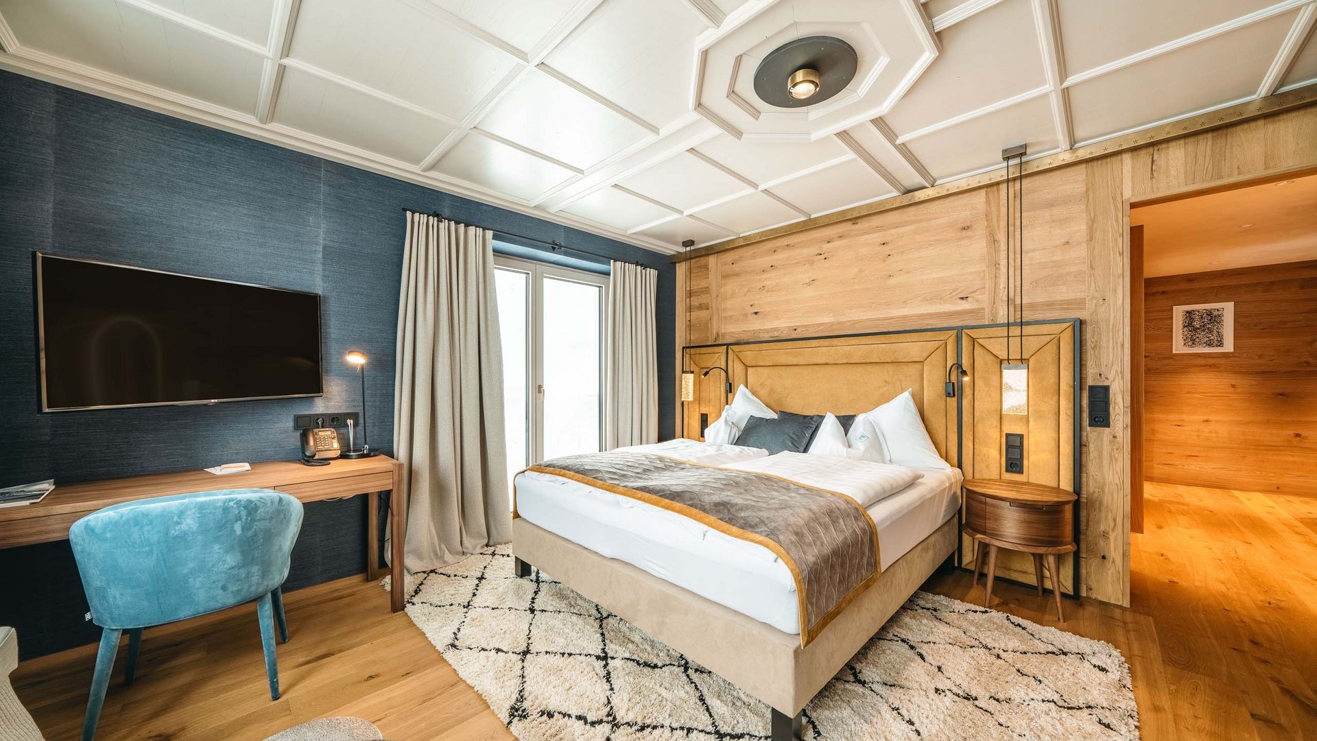 Holidays at the Arlberg: your hosts Cozy bedroom with wooden walls, double bed, and wall-mounted TV